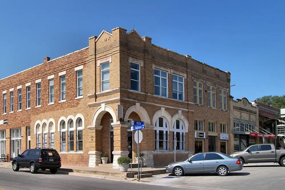 Historic brick corner building at Main and Railroad streets in Pflugerville, Texas